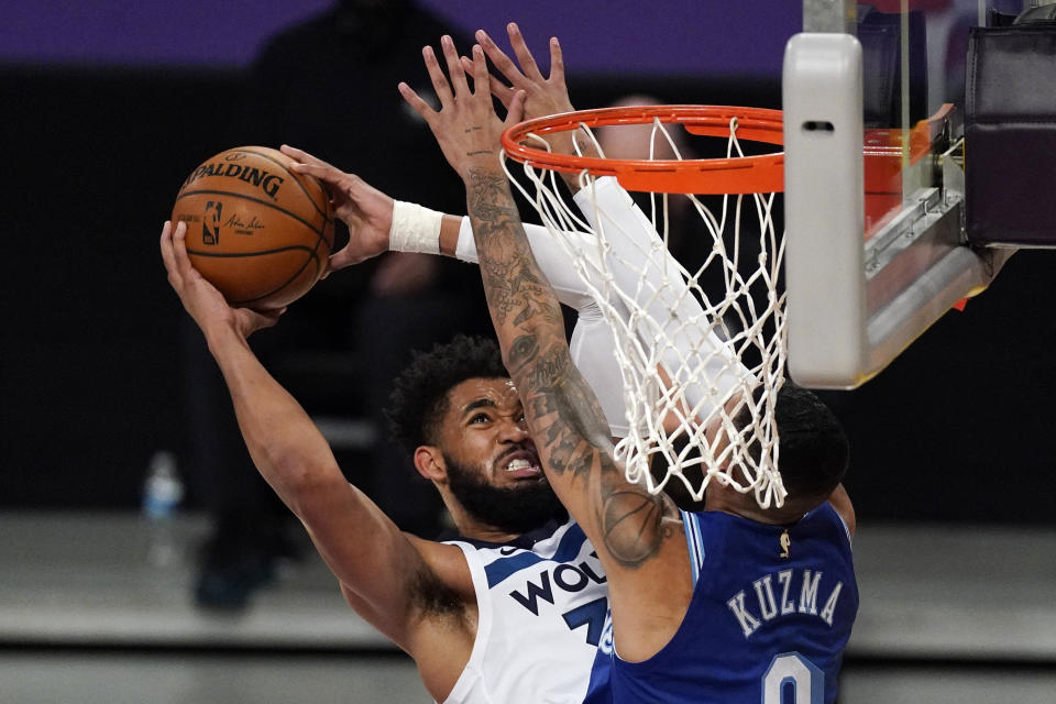 Minnesota Timberwolves center Karl-Anthony Towns, left, shoots as Los Angeles Lakers forward Kyle Kuzma defends during the first half of an NBA basketball game Tuesday, March 16, 2021, in Los Angeles. (AP Photo/Mark J. Terrill)