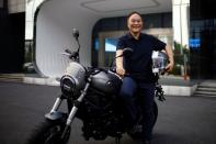 Zhejiang Geely Holding Group's Chairman Li Shufu poses for pictures with a Benelli Leoncino 800 motorcycle at Geely headquarters in Hangzhou