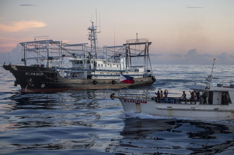 The ML Kalayaan sails past a Chinese fishing trawler. (Photo: Lisa Marie David/Bloomberg)