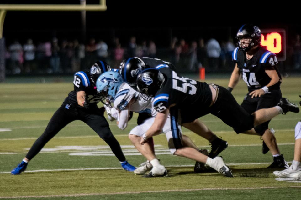 North Penn running back Matthew Pownall is taken down by Central Bucks South defensive backs, Dallon Smith, left, and Dan McCusker, back, and linebacker Elliott Francesco, right,