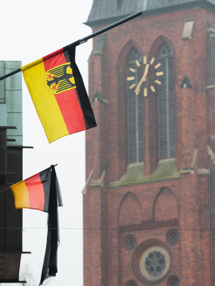 German flags fly at half-staff in front of the St. Sixtus Church in Haltern Germany