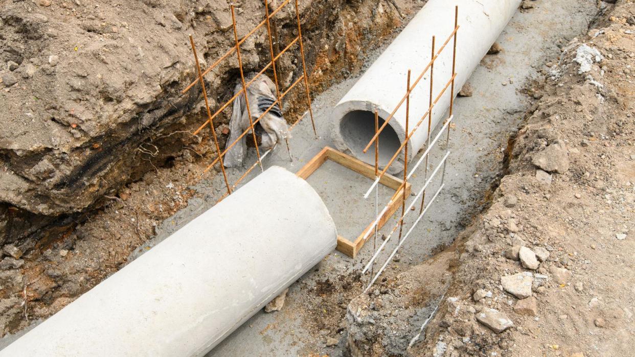 Large sewage concrete pipes in a trench on a building site