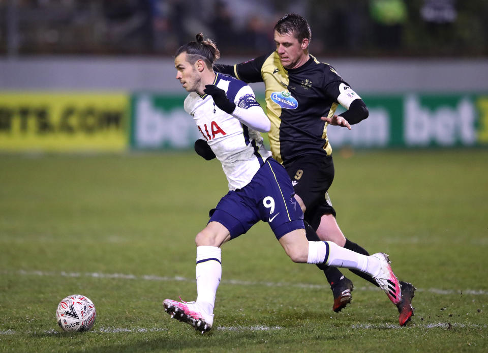 CROSBY, ENGLAND - JANUARY 10: Gareth Bale of Tottenham goes past Niall Cummins of Mafrine during the FA Cup Third Round match between Marine and Tottenham Hotspur at Rossett Park on January 10, 2021 in Crosby, England. Sporting stadiums around England remain under strict restrictions due to the Coronavirus Pandemic as Government social distancing laws prohibit fans inside venues resulting in games being played behind closed doors. (Photo by Tottenham Hotspur FC/Tottenham Hotspur FC via Getty Images)