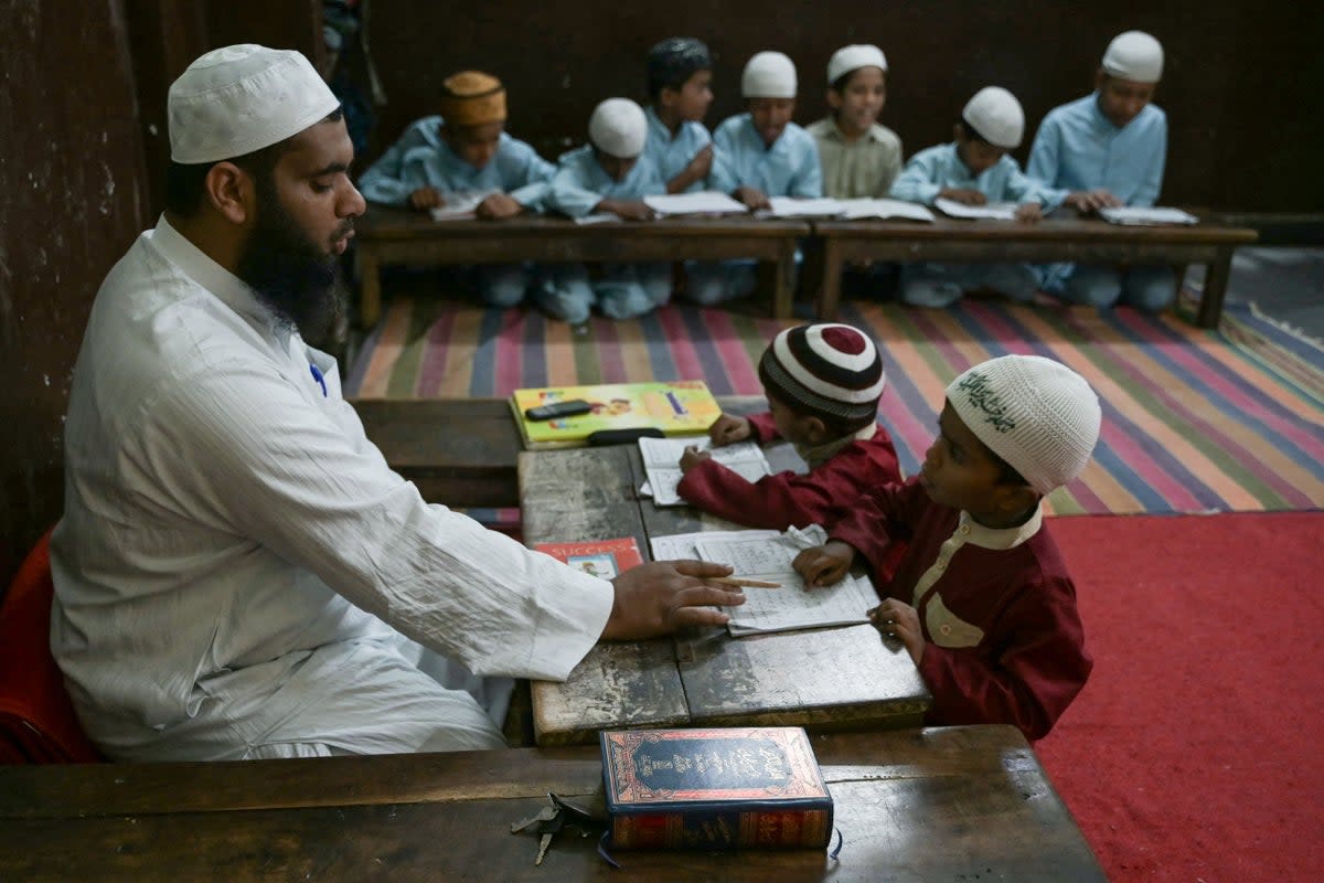 A teacher watches as students recite the Holy Quran in a classroom during the Islamic holy month of Ramadan (AFP via Getty Images)