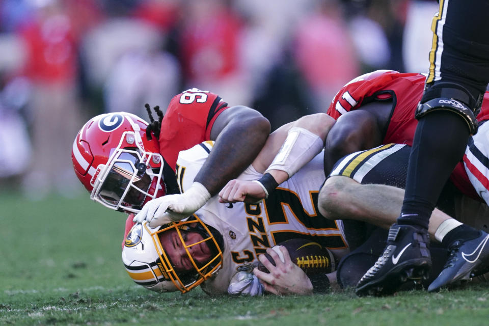 Missouri quarterback Brady Cook (12) is sacked by Georgia defensive lineman Zion Logue (96) and linebacker Jalon Walker (11) during the first half of an NCAA college football game, Saturday, Nov. 4, 2023, in Athens, Ga. (AP Photo/John Bazemore)