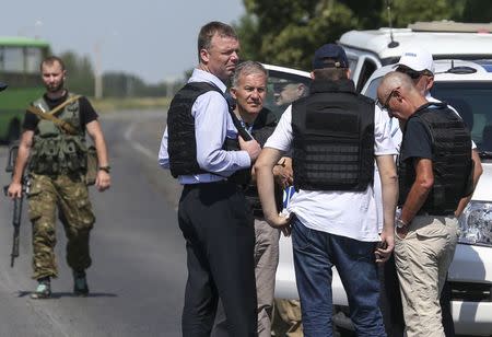 Alexander Hug (front C), deputy head for the Organisation for Security and Cooperation in Europe's (OSCE) monitoring mission in Ukraine, stands with members of his team on the way to the site in eastern Ukraine where the downed Malaysian airliner MH17 crashed, outside Donetsk, July 30, 2014. REUTERS/Sergei Karpukhin