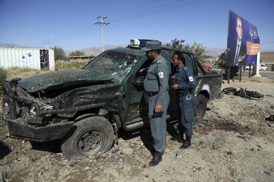 Afghan police inspect the site of a suicide attack, in northern Parwan province, Afghanistan, Tuesday, Sept. 17, 2019. The Taliban suicide bomber on a motorcycle targeted presidential guards who were protecting President Ashraf Ghani at a campaign rally in northern Afghanistan on Tuesday, killing over 20 people and wounding over 30. Ghani was present at the venue but was unharmed, according to his campaign chief. (AP Photo/Rahmat Gul)