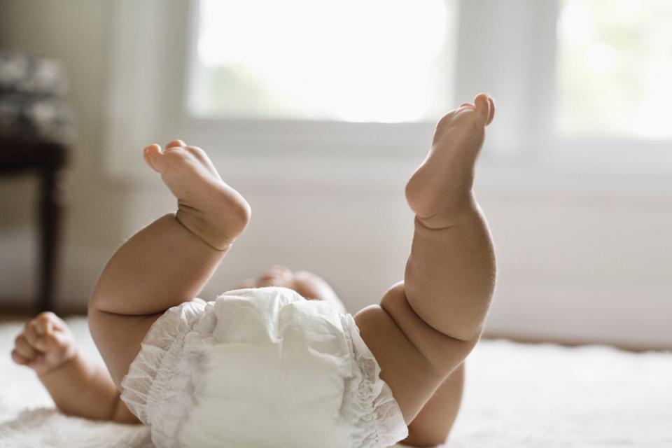 An image of a baby laying on the floor.