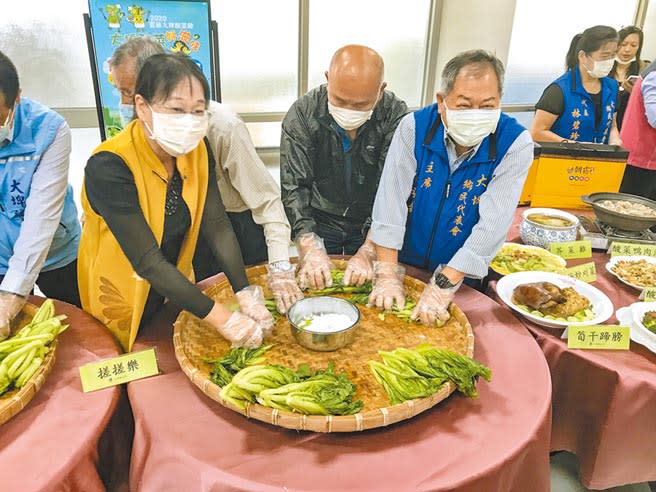 雲林縣副縣長謝淑亞大力推廣大埤鄉酸菜，現場將芥菜以鹽巴搓揉，學習製作道地酸菜。（周書聖攝）