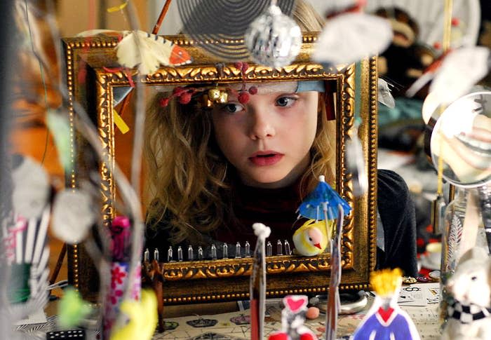 Elle Fanning as a child looks through a gold frame