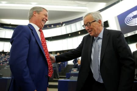 European Commission President Jean-Claude Juncker talks with Brexit Party leader Nigel Farage before a debate on Brexit at the European Parliament in Strasbourg