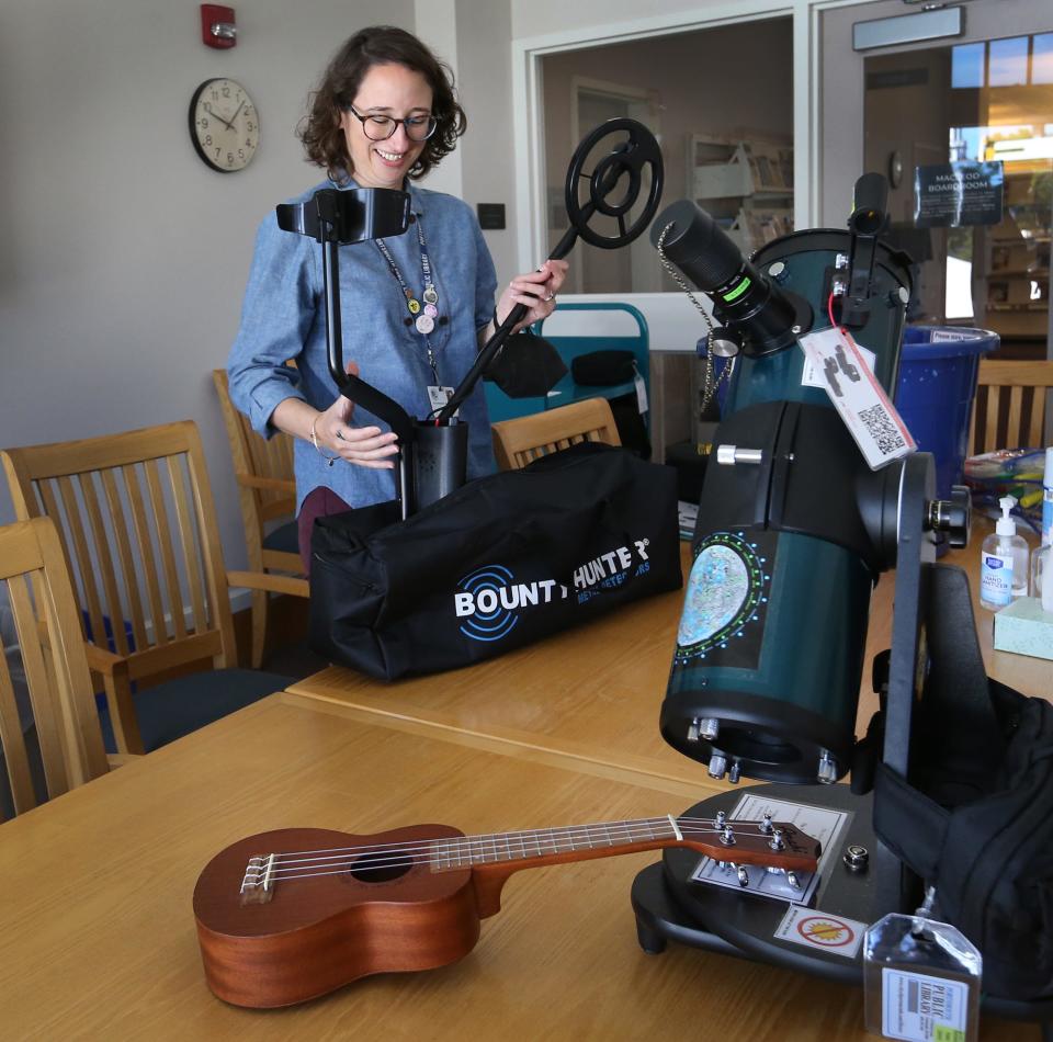 Emerging technologies librarian Michaela Pugh takes a metal detector from the bag and displays other available items such as a telescope, GoPro camera, ukulele, and the Oculus Quest VR,  as items available to borrow at Portsmouth Public Library.