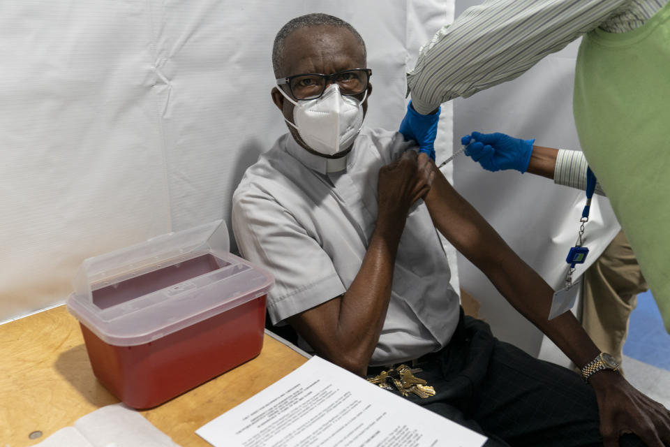 The Rev. Dr. Alfred Cockfield, Pastor God's Battalion of Prayer Church receives the first dose of the Pfizer-BioNTech COVID-19 vaccine at a pop-up COVID-19 vaccination site at the church, Wednesday, Feb. 3, 2021, in the Brooklyn borough of New York. Rev. Cockfield and First Lady Linette received the vaccine in a public show of trust and faith in the vaccine. (AP Photo/Mary Altaffer)