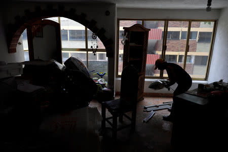 Maria Guadalupe Padilla removes items inside her apartment in the Tlalpan neighbourhood, where her building was damaged by the devastating earthquake, that took place in Mexico City last year, Mexico, August 28, 2018. Picture taken August 28, 2018. REUTERS/Henry Romero