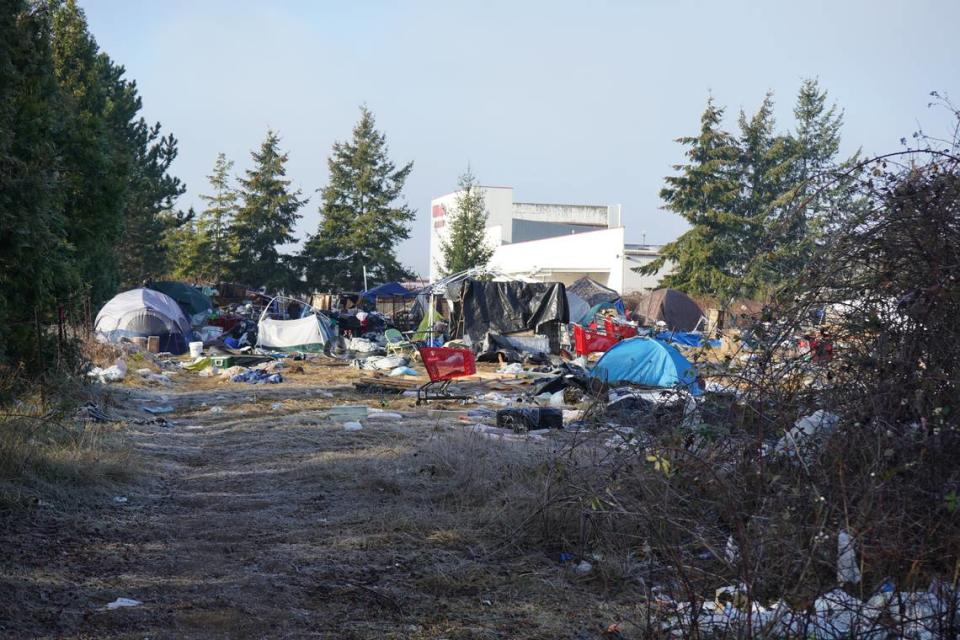 Tents and temporary shelters occupy the property at 4049 Deemer Road near WinCo Foods on Friday, Dec. 16, 2022, in Bellingham, Wash. The city of Bellingham sued the property owner for allegedly causing a public nuisance by not clearing the encampment on the property.