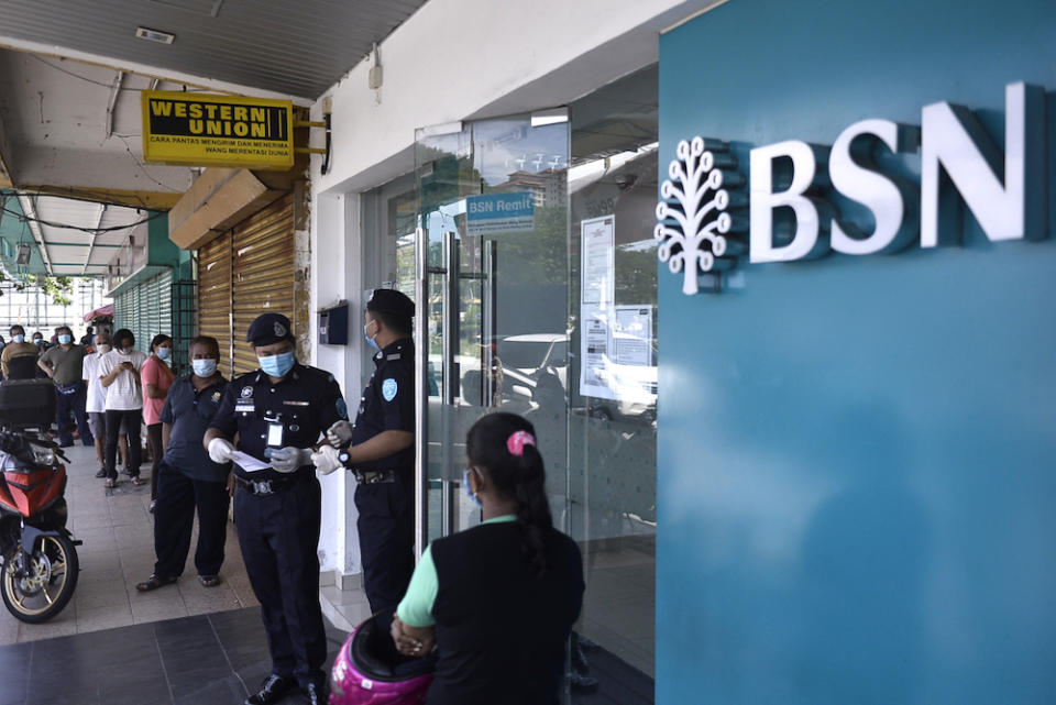 People queue in front of a Bank Simpanan Nasional branch in Kuala Lumpur April 6, 2020. — Picture by Miera Zulyana