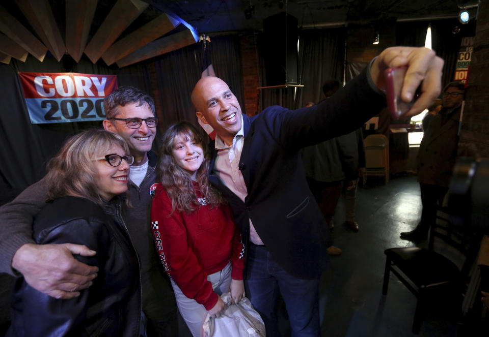 Democratic presidential candidate Sen. Cory Booker, D-N.J., takes a selfie with Mary Bichell, from left, her husband, Ken, and daughter, Maddie, 12, during an event at Smokestack in Dubuque, Iowa, on Sunday, Dec. 8, 2019. (Jessica Reilly/Telegraph Herald via AP)