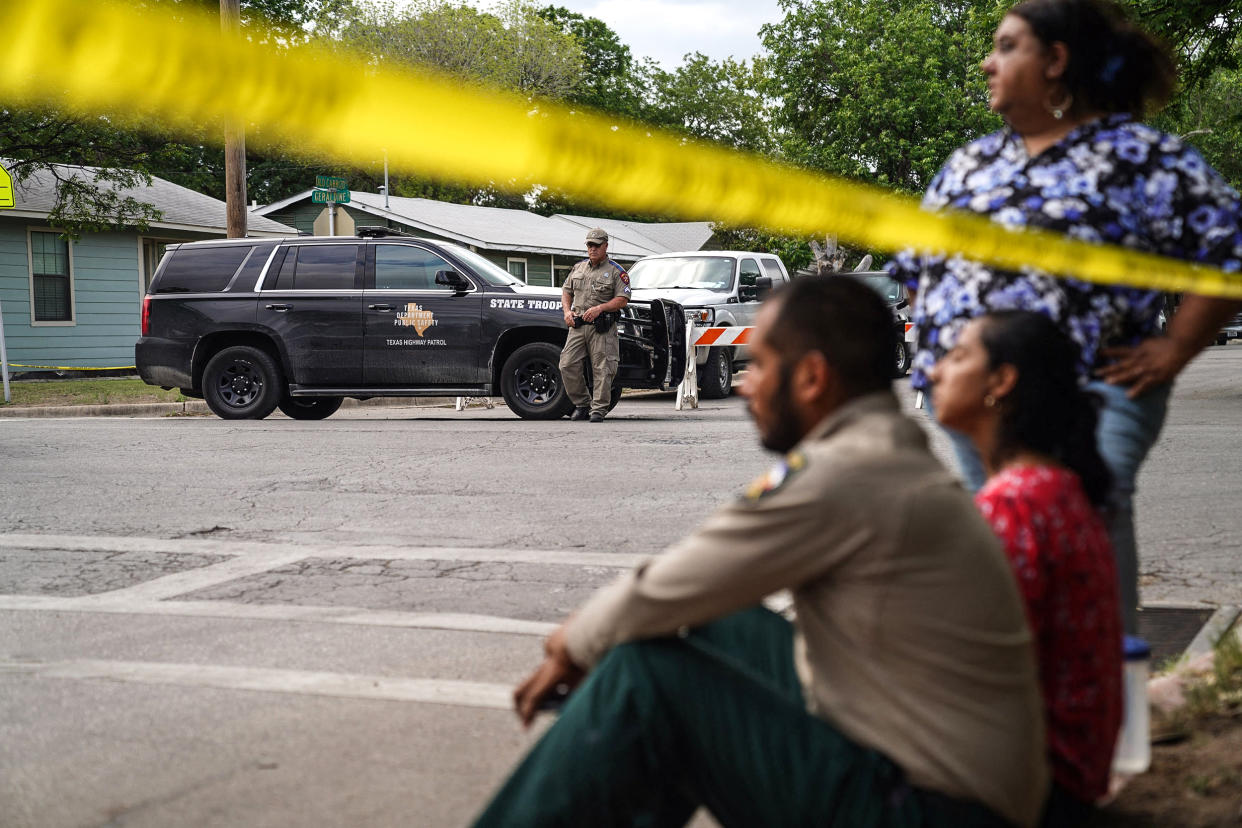 Image: People sit on the curb outside of Robb Elementary School as State troopers guard the area in Uvalde, Texas, on May 24, 2022. (Allison Dinner / AFP - Getty Images)