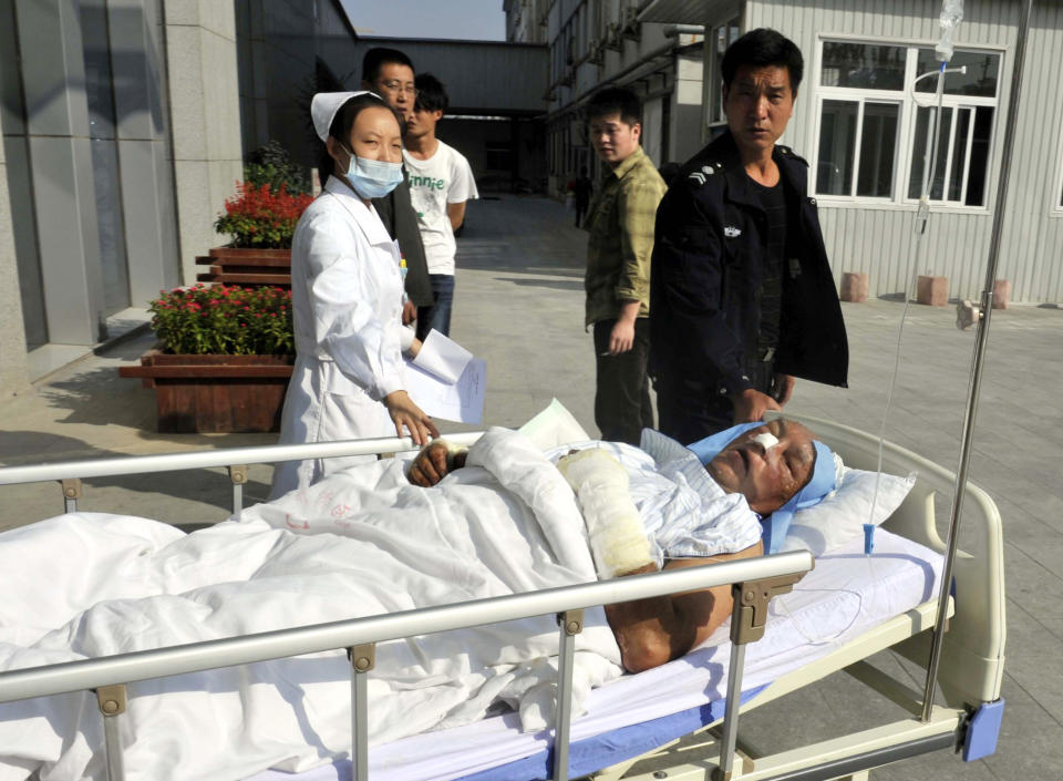 In this photo released by China's Xinhua News Agency, an injured German national is carried to the People's Hospital in Tianjin's Wuqing District after a road accident on an expressway near Tianjin, China, Monday, Oct. 1, 2012. Five Germans and a Chinese citizen were killed when their bus burst into flames after hitting the back of a truck Monday, Xinhua said. (AP Photo/Xinhua, Yue Yuewei) NO SALES