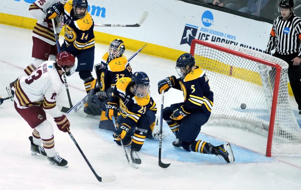 Quinnipiac's Victor Czerneckianair, left, goalie Vinny Duplessis, Cristophe Tellier and CJ McGee watch as a shot from Boston College forward Jack Malone heads into the net in overtime to win Snday's game for the Eagles.