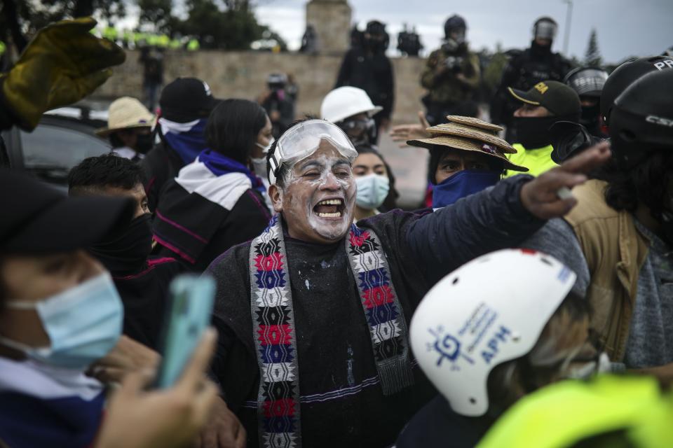A demonstrator shouts at police during an anti-government protest in Bogota, Colombia, Wednesday, June 9, 2021. Ongoing protests have been triggered by proposed tax increases on public services, fuel, wages and pensions. (AP Photo/Ivan Valencia)