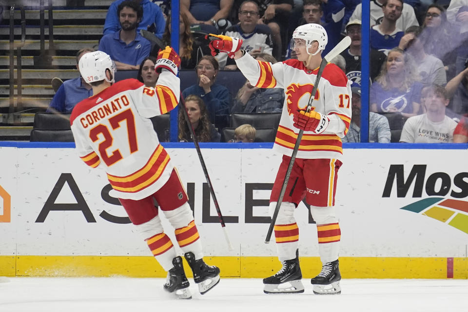 Calgary Flames center Yegor Sharangovich (17) celebrates his goal against the Tampa Bay Lightning with right wing Matt Coronato (27) during the second period of an NHL hockey game Thursday, March 7, 2024, in Tampa, Fla. (AP Photo/Chris O'Meara)