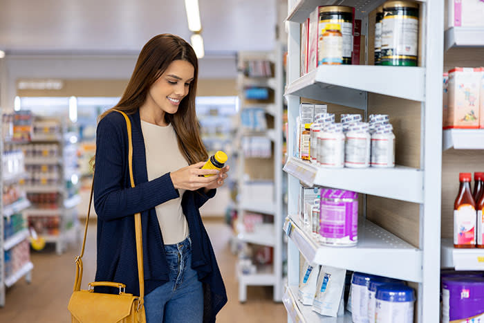 mujer con un bote de suplementos