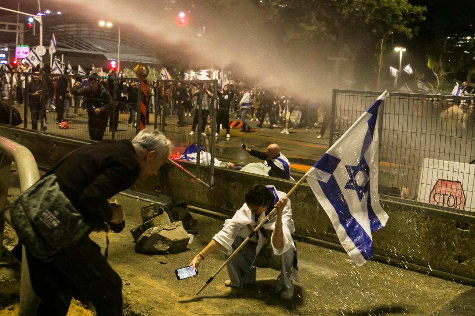 An Israeli protester holds the Israeli flag during a demonstration on March 27, 2023 in Tel Aviv, Israel.