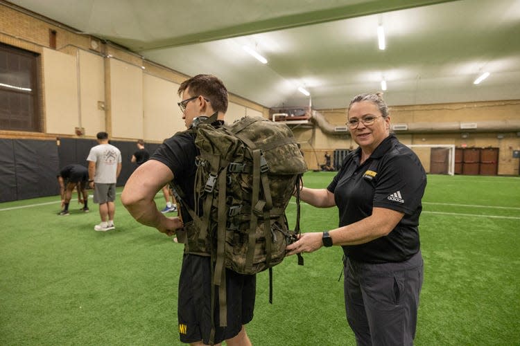 Jennifer Earl-Boehm, a professor and athletic trainer at the University of Wisconsin-Milwaukee, shows a rucksack on an ROTC student participating in rucking.