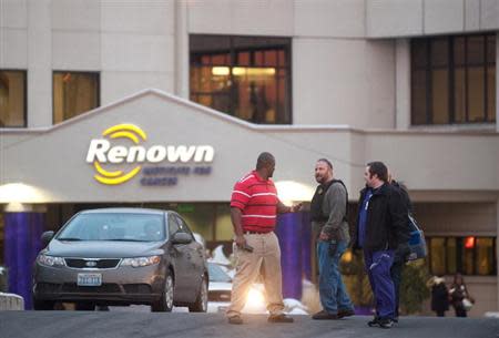 A Reno Police officer (2nd L) talks with employees of the Renown Regional Medical Center following a lockdown in Reno, Nevada December 17, 2013. REUTERS/James Glover