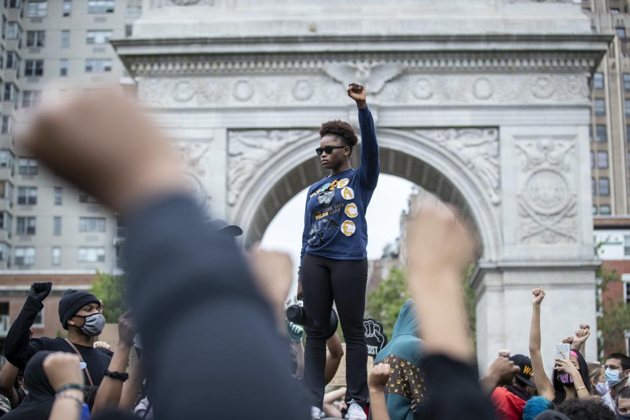 <span class="caption">A protester raises a fist in New York's Washington Square Park during a June 2, 2020 demonstration.</span> <span class="attribution"><a class="link " href="https://www.gettyimages.com/detail/news-photo/protester-holds-up-a-raised-fist-with-a-shirt-that-has-news-photo/1242649150" rel="nofollow noopener" target="_blank" data-ylk="slk:Ira L. Black/Corbis via Getty Images;elm:context_link;itc:0;sec:content-canvas">Ira L. Black/Corbis via Getty Images</a></span>