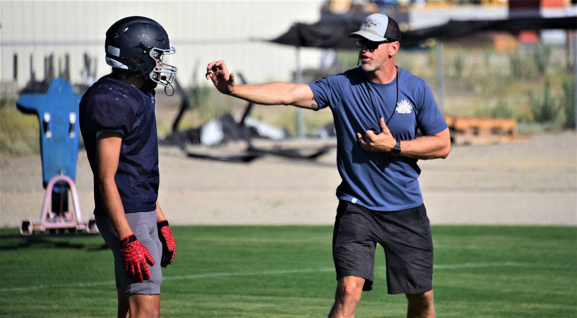 Stone Ridge Christian first-year head coach Anthony DeJager talks to senior Sawyer Wood during practice on Tuesday, Aug. 8, 2023 at Castle Field.