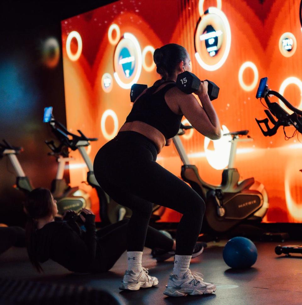 woman lifting dumbells at lumin fitness studio