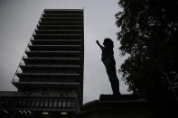 A new black resin and steel statue entitled "A Surge of Power (Jen Reid) 2020" by artist Marc Quinn stands after the statue was put up in the morning on the empty plinth of the toppled statue of 17th century slave trader Edward Colston, which was pulled down during a Black Lives Matter protest in Bristol, England, Wednesday, July 15, 2020. On June 7, anti-racism demonstrators pulled the 18-foot (5.5-meter) bronze likeness of Colston down, dragged it to the nearby harbor and dumped it in the River Avon, sparking both delight and dismay in Britain and beyond. (AP Photo/Matt Dunham)