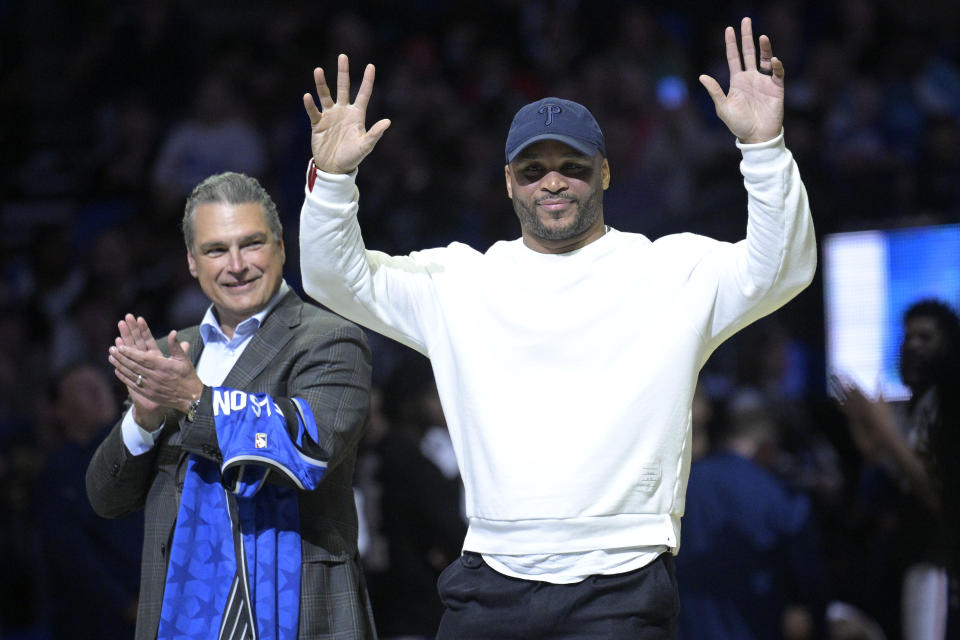 Former Orlando Magic guard Jameer Nelson, right, is honored on the court as Magic CEO Alex Martins applauds during a timeout in the first half of the team's NBA basketball game against the Philadelphia 76ers, Friday, Jan. 19, 2024, in Orlando, Fla. (AP Photo/Phelan M. Ebenhack)