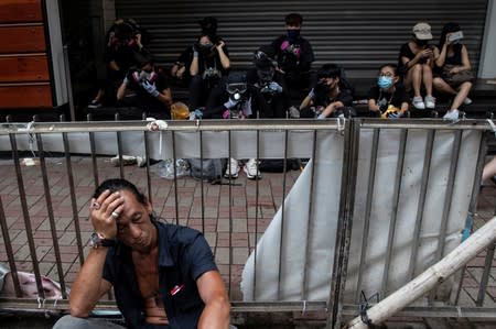 A man rests as demonstrators get ready to attend a protest in Hong Kong