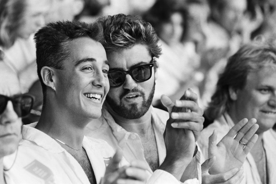 Live Aid dual venue benefit concert held on 13th July 1985 at Wembley Stadium in London, England, and the John F Kennedy Stadium in Philadelphia, Pennsylvania, United States, the concerts were organised as a follow up to the Band Aid single 'Do They Know Its Christmas?', the brainchild of Bob Geldof and Midge Ure, to raise money for victims of the famine in Ethiopia,Picture shows Wham duo Andrew Ridgeley and George Michael watching the concert at Wembley. (Photo by Mike Maloney/Daily Mirror/Mirrorpix/Getty Images)