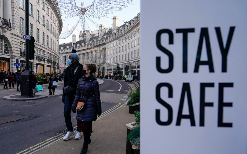 Londoners wearing face masks on Regent Street ahead of the introduction of a new mask mandate in shops and on public transport - Alberto Pezzali/AP Photo