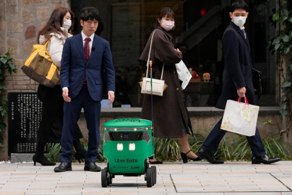 優食日本分公司3月6日開始在東京限定區域試辦機器人外送服務，圖為3月5日的街頭實演。美聯社