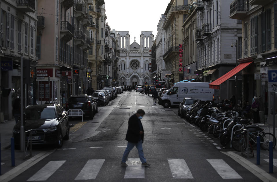 Un hombre cruza la calle frente a la iglesia de Notre Dame, en Niza, sur de Francia, donde un hombre apuñaló y mató a tres personas el jueves 29 de octubre de 2020. (AP Foto/Daniel Cole)