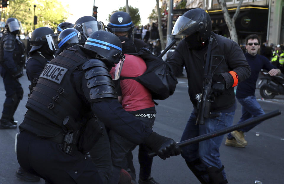 Police scuffle with protestors during a yellow vest demonstration in Paris, Saturday, April 20, 2019. French yellow vest protesters are marching anew to remind the government that rebuilding the fire-ravaged Notre Dame Cathedral isn't the only problem the nation needs to solve. (AP Photo/Francisco Seco)