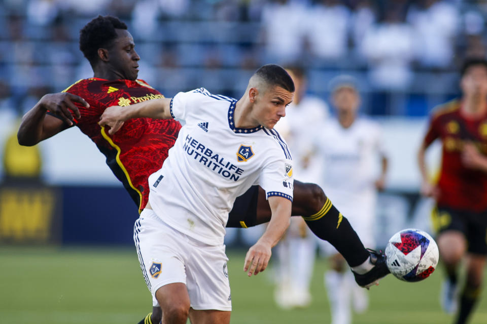 Seattle Sounders defender Yeimar Gomez Andrade, back, kicks the ball next to LA Galaxy forward Dejan Joveljic during the second half of an MLS soccer match in Carson, Calif., Saturday, April1, 2023. (AP Photo/Ringo H.W. Chiu)