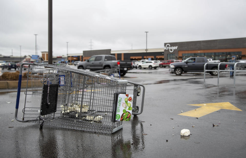 Shopping carts sit toppled over after being blown around a grocery store's parking lot on Scottsville Road in Bowling Green, Ky., after another tornado warning was issued late Saturday morning, Jan. 1, 2022, for Warren and surrounding counties, following the devastating tornadoes that tore through town on Dec. 11, 2021. Though the damage from Saturday's storm proved less catastrophic than the system that passed through in December, heavy rain and strong winds battered the area, causing damage along Cave Mill Road and the surrounding area. (Grace Ramey/Daily News via AP)