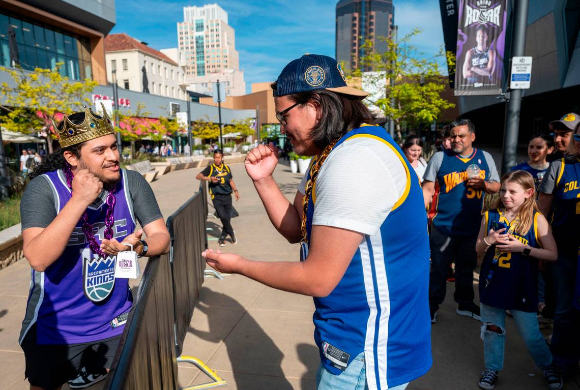 Kings fan Luis Hernandez, of Sacramento, and Golden State Warriors fan Manuel Arviso, who just moved from Germany, play a game of rock–paper–scissors while waiting in line to enter the Golden 1 Center before their teams’ play-in game Tuesday.