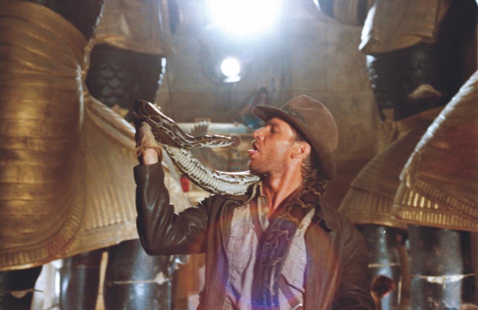 Indiana Jones famously doesn't like snakes, but Harrison Ford hams it up with one while filming the Well of Souls scene in "Raiders of the Lost Ark."