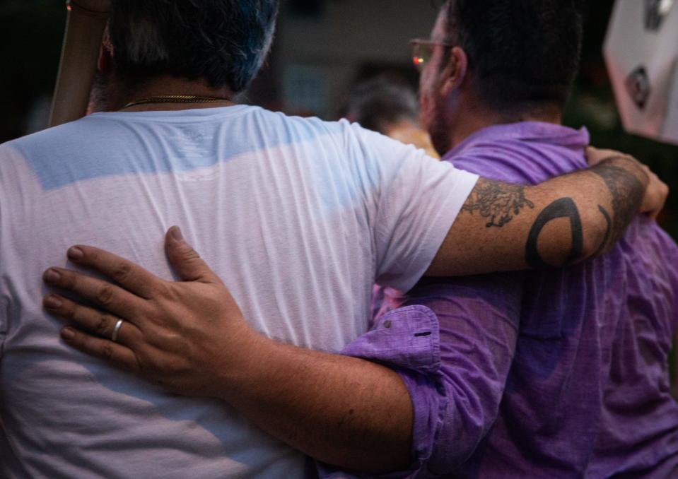 J.C. King embraces a friend as they walk in Thursday's procession.