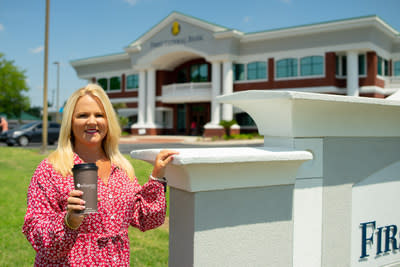 Gigi Register, Senior Vice President at First Federal Bank, holds Ellianos Coffee cup outside First Federal Bank's John S. Flood Financial Center in Lake City, Florida.