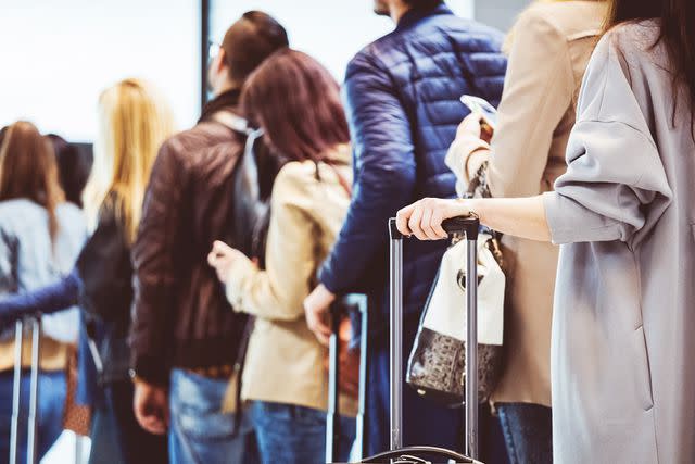 <p>izusek/Getty</p> People waiting in line at the airport