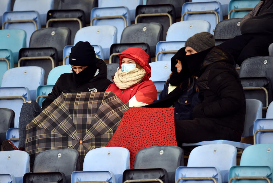 Fans in the stands wrapped up against the weather during the Barclay Women's Super League match at the Manchester City Academy Stadium, Manchester. Picture date: Sunday December 4, 2022.