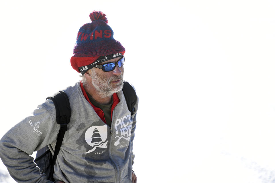 In this photo taken Jan. 7, 2020, British artist Simon Beck rests after completing a large geometrical design on a frozen reservoir near Silverthorne, Colo. The design, which incorporated a series of spirals, spanned the length of about two soccer fields and took more than a dozen hours to complete. (AP Photo/Thomas Peipert)